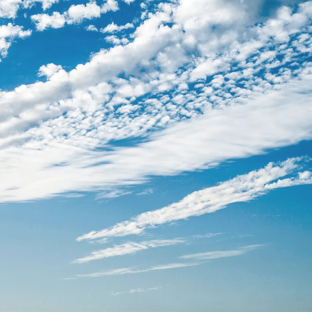 A bright blue sky with light, wispy white clouds, representing the air element and its relationship to breath, movement, and clear communication.