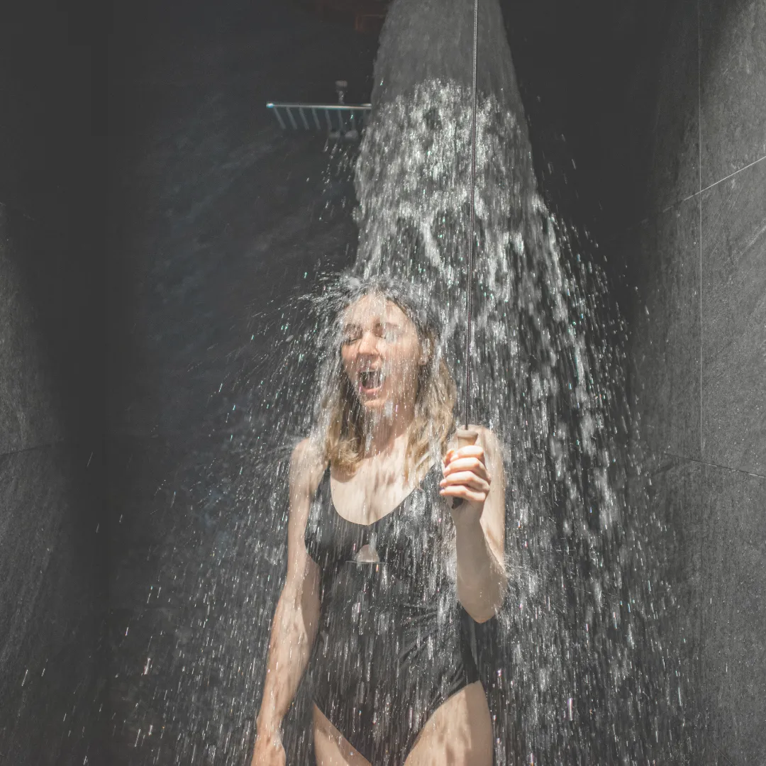 A woman practicing cold exposure in an ice bath, a powerful form of hormetic stress used to boost mood, reduce inflammation, and improve focus.