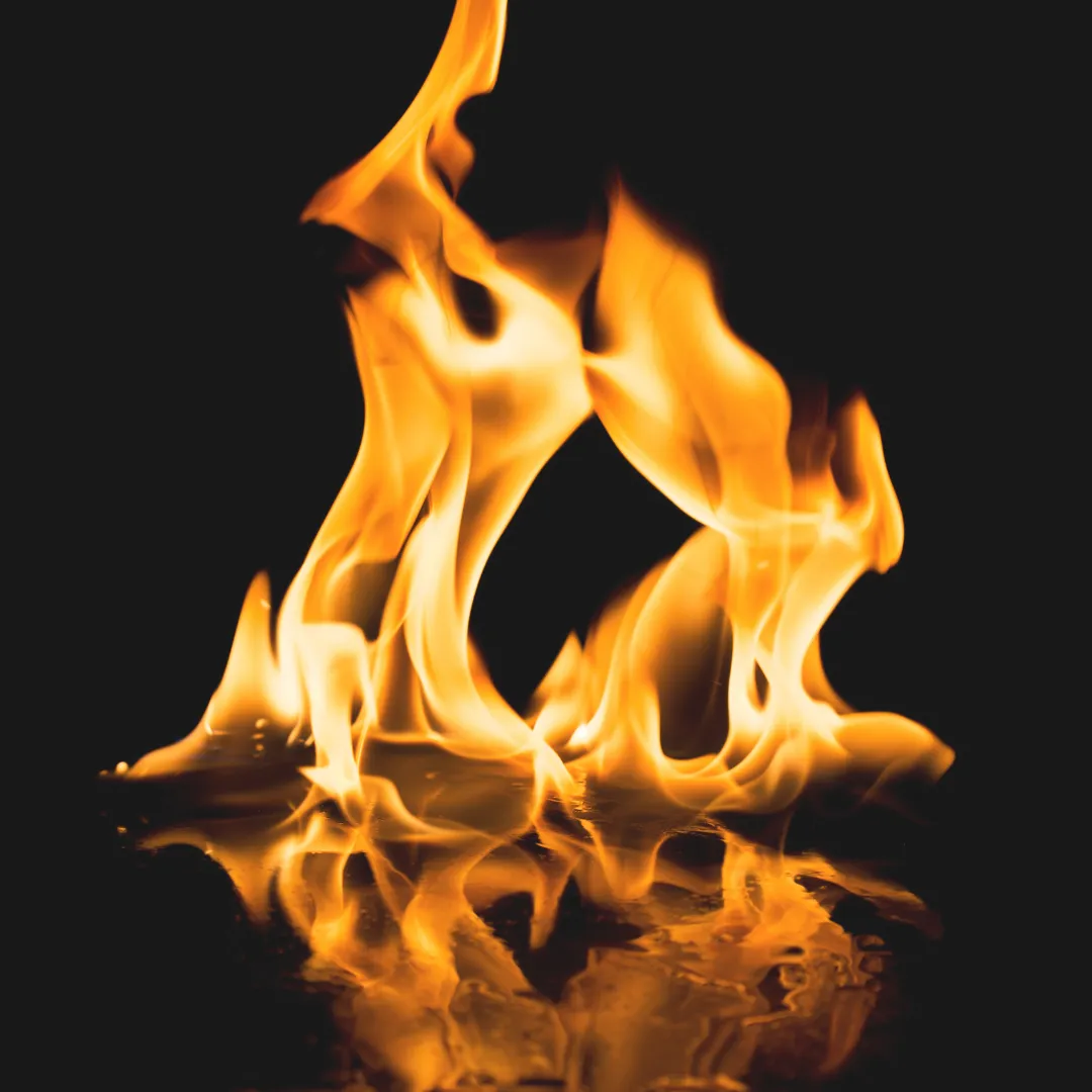 Vibrant orange flames on a black background, symbolizing the fire element which governs transformation, digestion, and passion in holistic health.