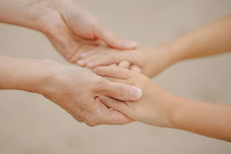 Close-up of a thumb pressing firmly into a person's forearm against a dark background
