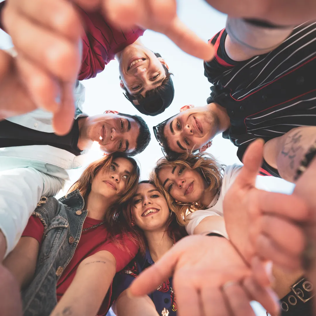A group of young Gen Z friends looking down at the camera, representing the generation that relies on ChatGPT for relationship advice and social guidance.