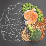 A brain outline on a chalkboard, with one half filled with healthy foods like salmon, nuts, and broccoli, visually representing the gut-brain connection and its role in emotional health.