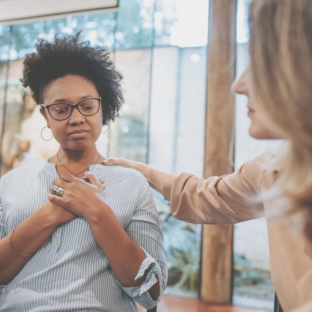 Woman receiving emotional support during a heart chakra healing session for emotional balance.