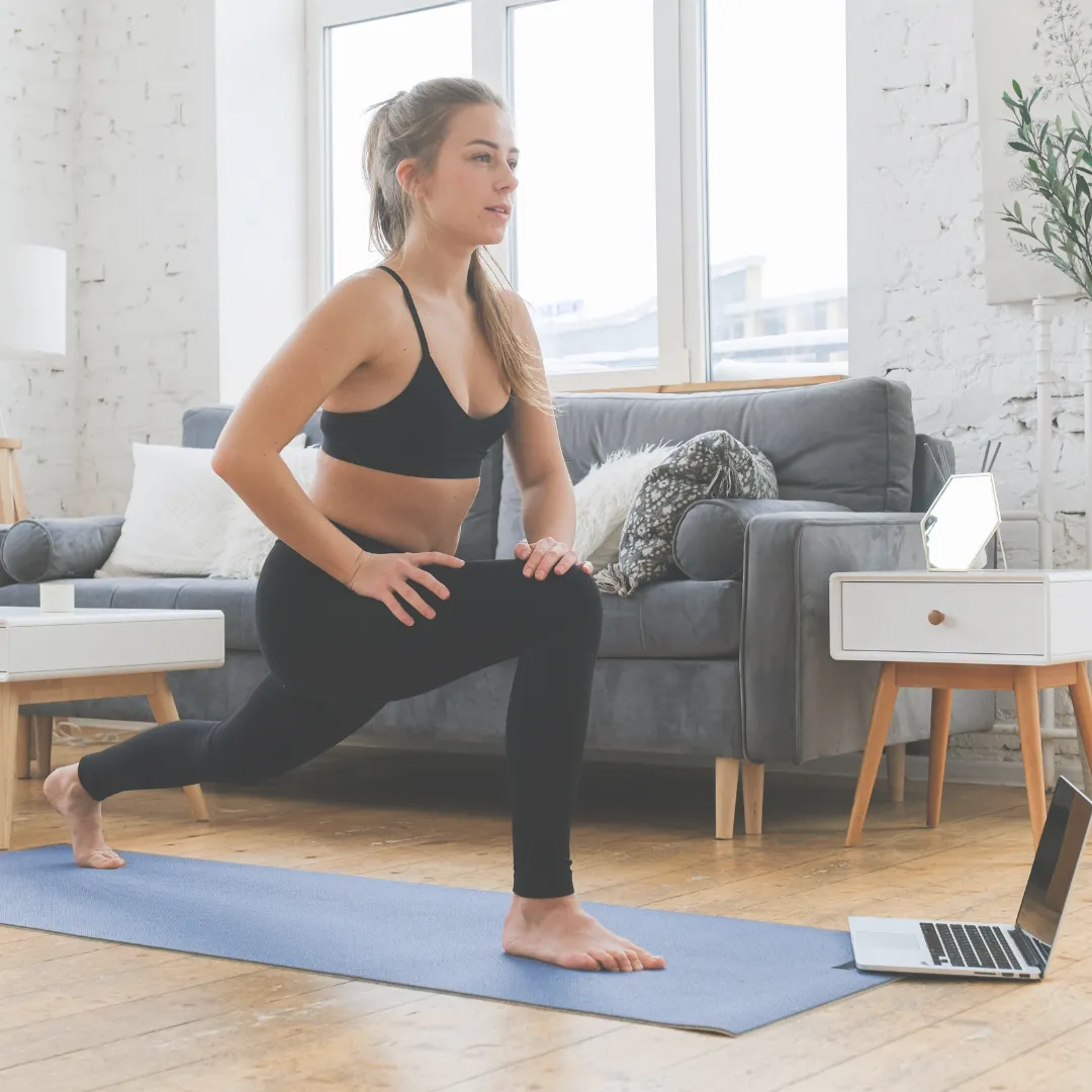 Young woman performing lunges in a Longevity Room during a virtual wellness session.