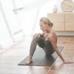 Mature woman practicing yoga in a bright Longevity Room designed for holistic wellness.