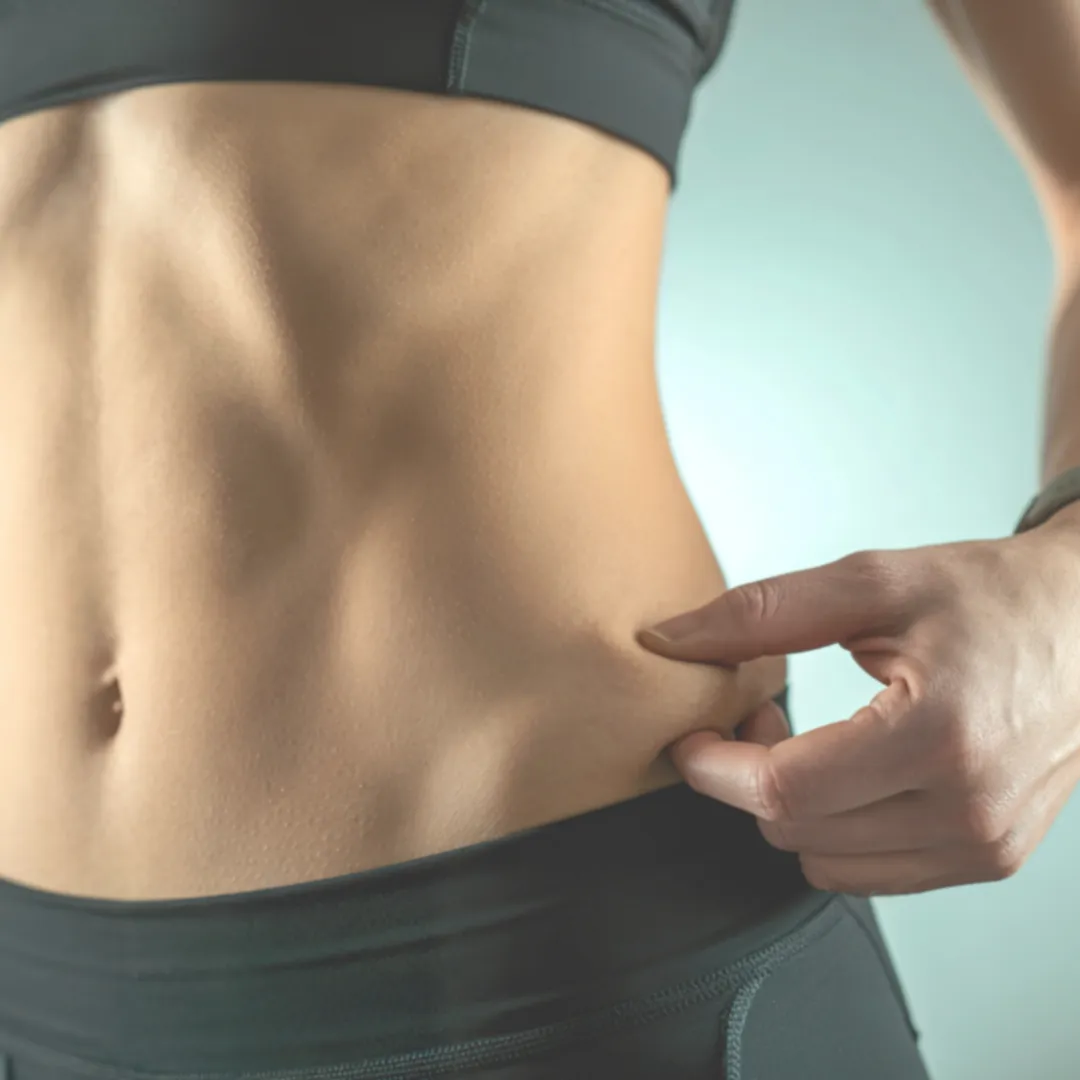 A very lean torso showing a low body fat percentage being pinched at the waist.