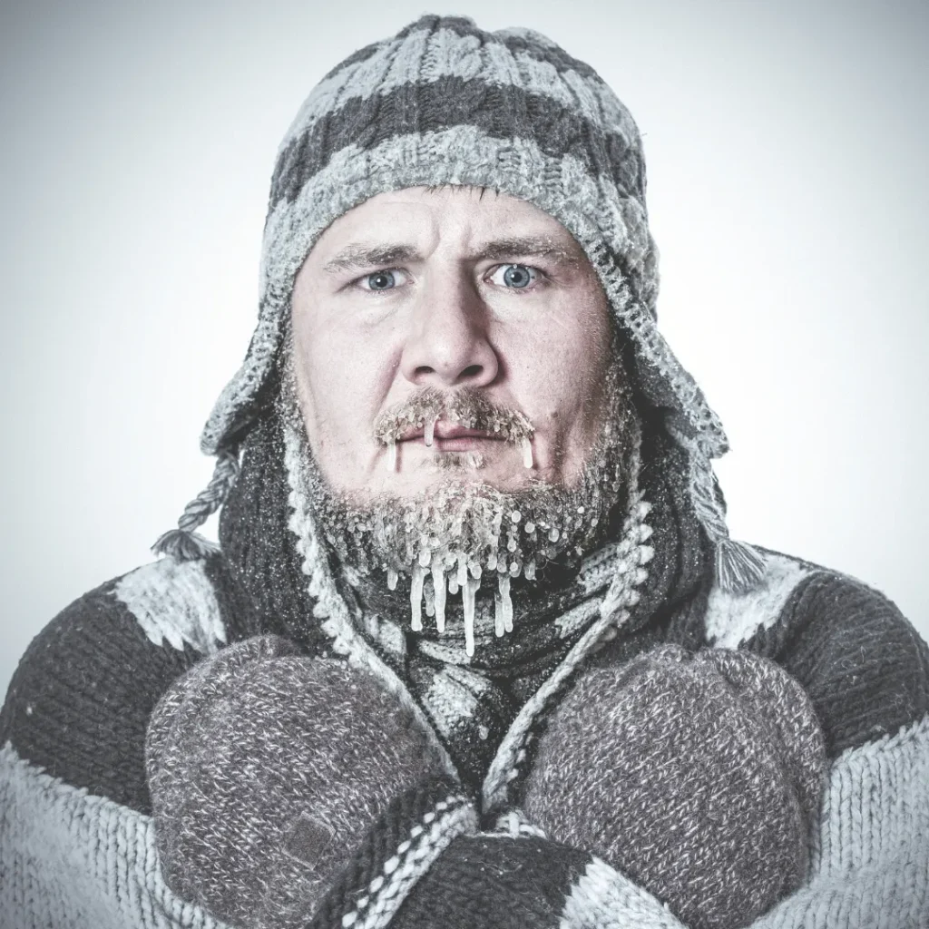 Close-up of a man with a frozen face and ice on his beard, visually representing the feeling of winter lethargy, seasonal affective disorder, and the nervous system's freeze response.
