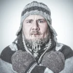 Close-up of a man with a frozen face and ice on his beard, visually representing the feeling of winter lethargy, seasonal affective disorder, and the nervous system's freeze response.