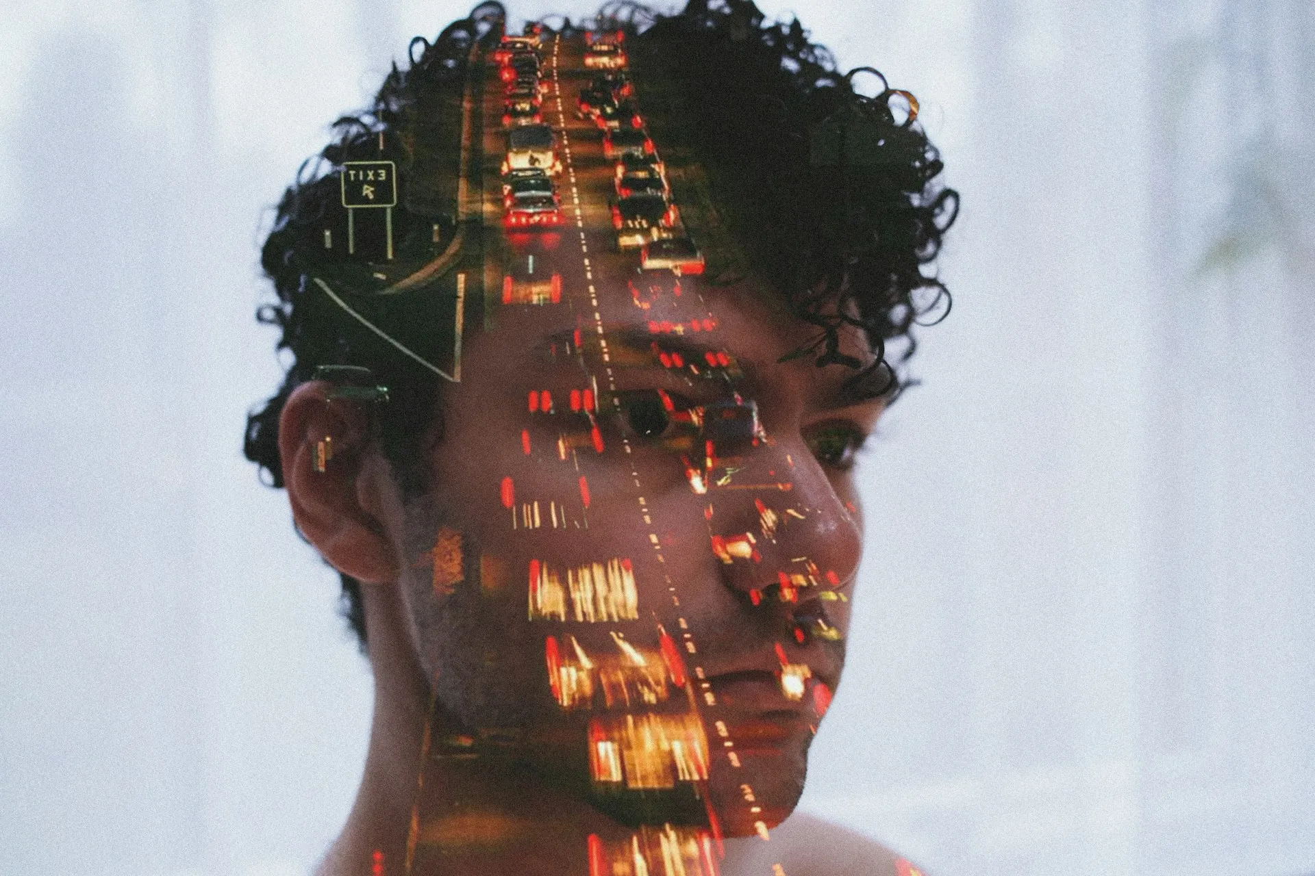 Double exposure portrait of a man with highway traffic representing brain fog and nervous system overstimulation.