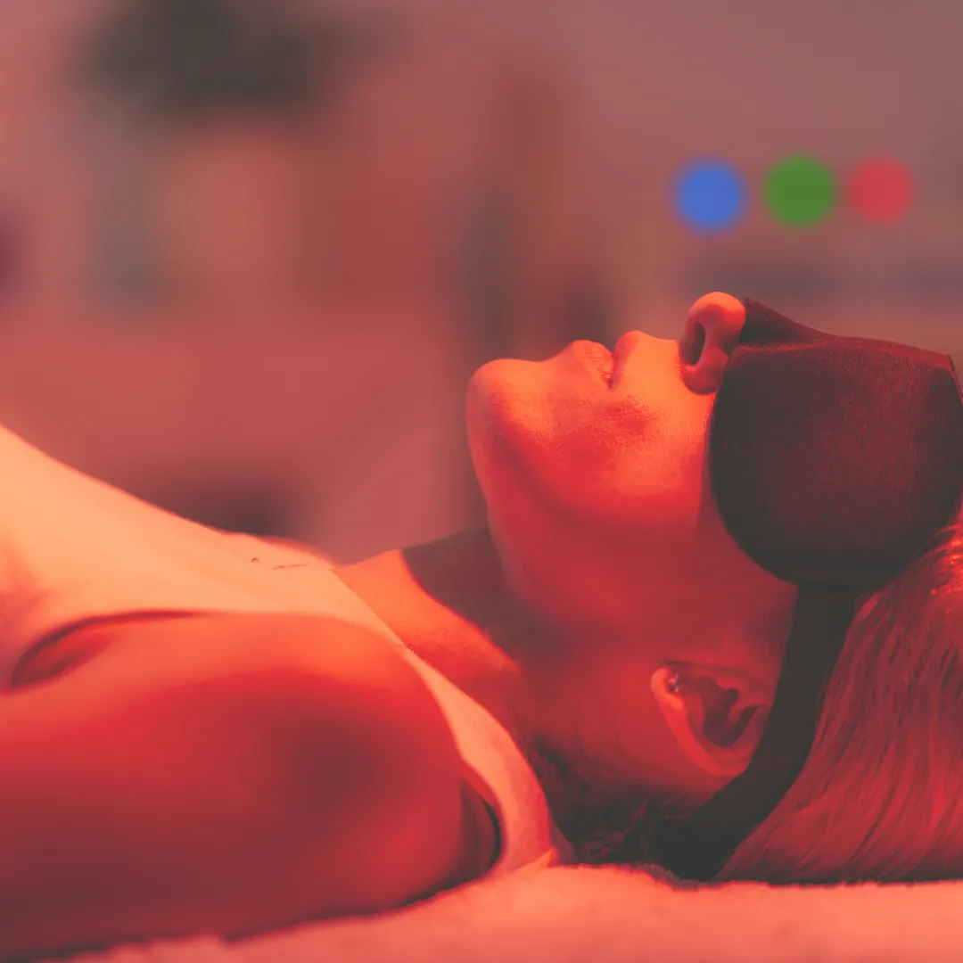 A woman receiving red light therapy to support skin rejuvenation and reduce inflammation by stimulating cellular energy (ATP).