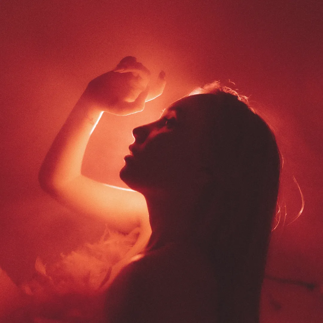 Silhouette of a person receiving targeted red light therapy and near-infrared photobiomodulation for deep tissue recovery.