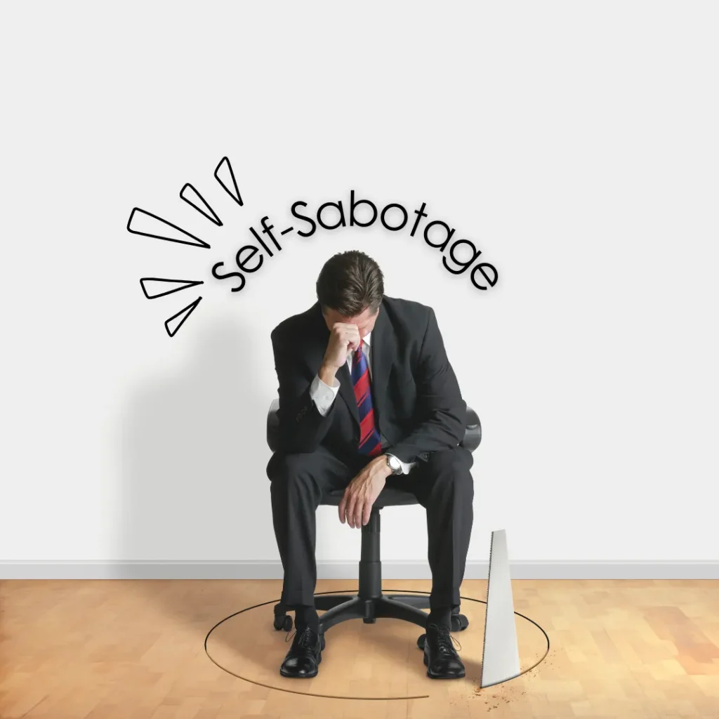 A frustrated businessman sitting on a chair above a hole being sawed into the floor, illustrating the concept of self-sabotage and blocking one's own success.
