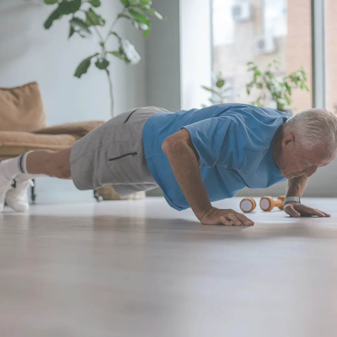 Senior man doing push-ups in a Longevity Room optimized for strength and energy with Thera Wellness.