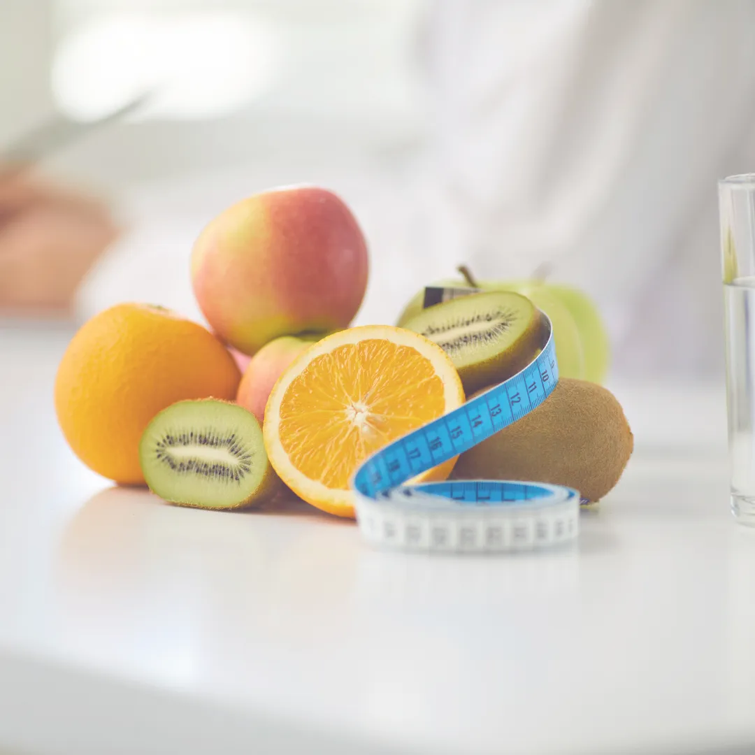 Fresh fruits with measuring tape symbolizing healthy eating for weight loss